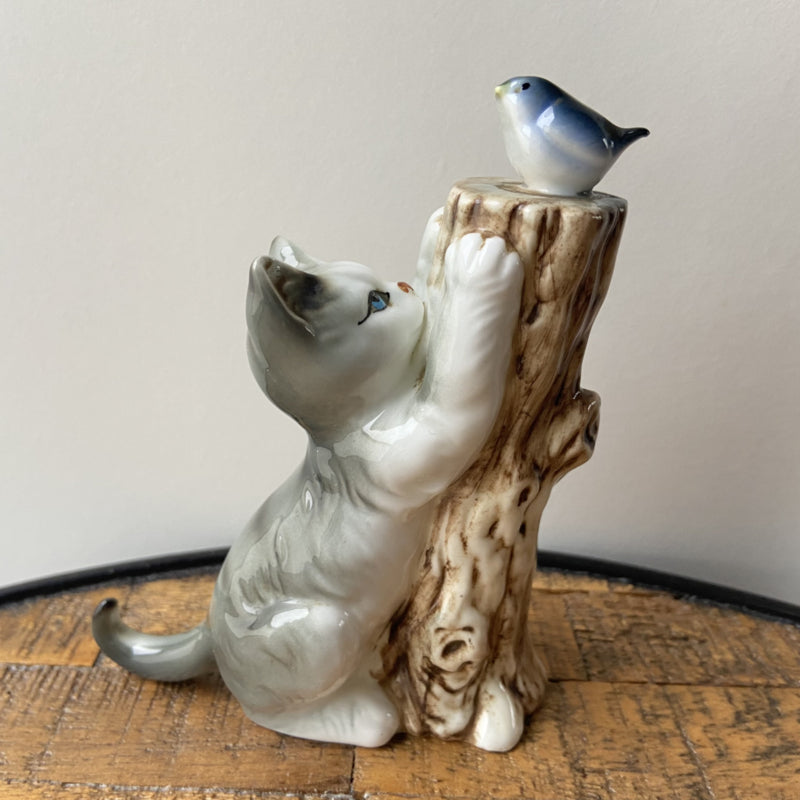 Vintage kat met vogel op boomstronk