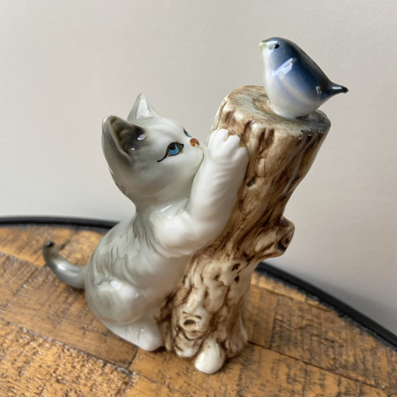 Vintage kat met vogel op boomstronk