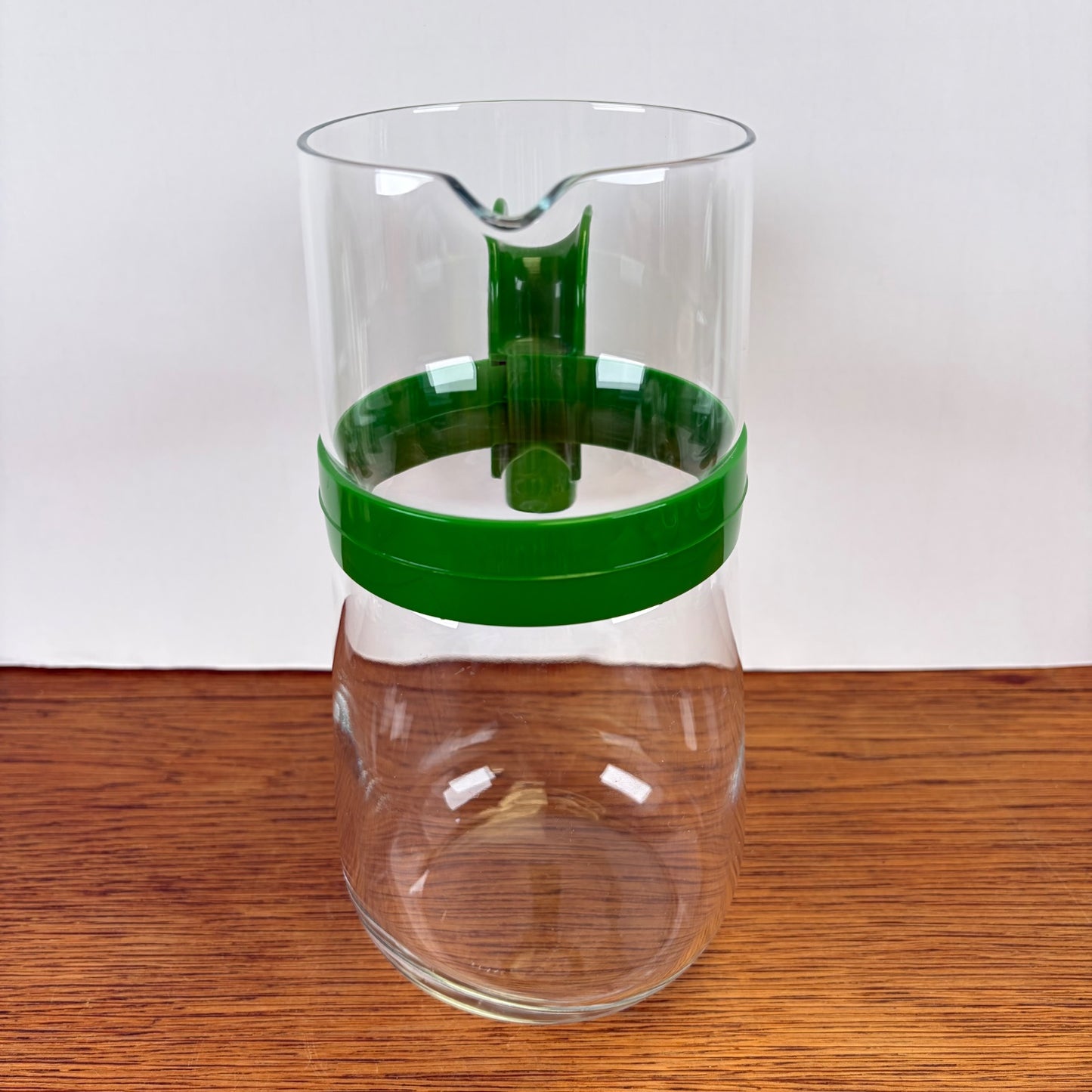 Vintage waterkan met groene kunststof houder