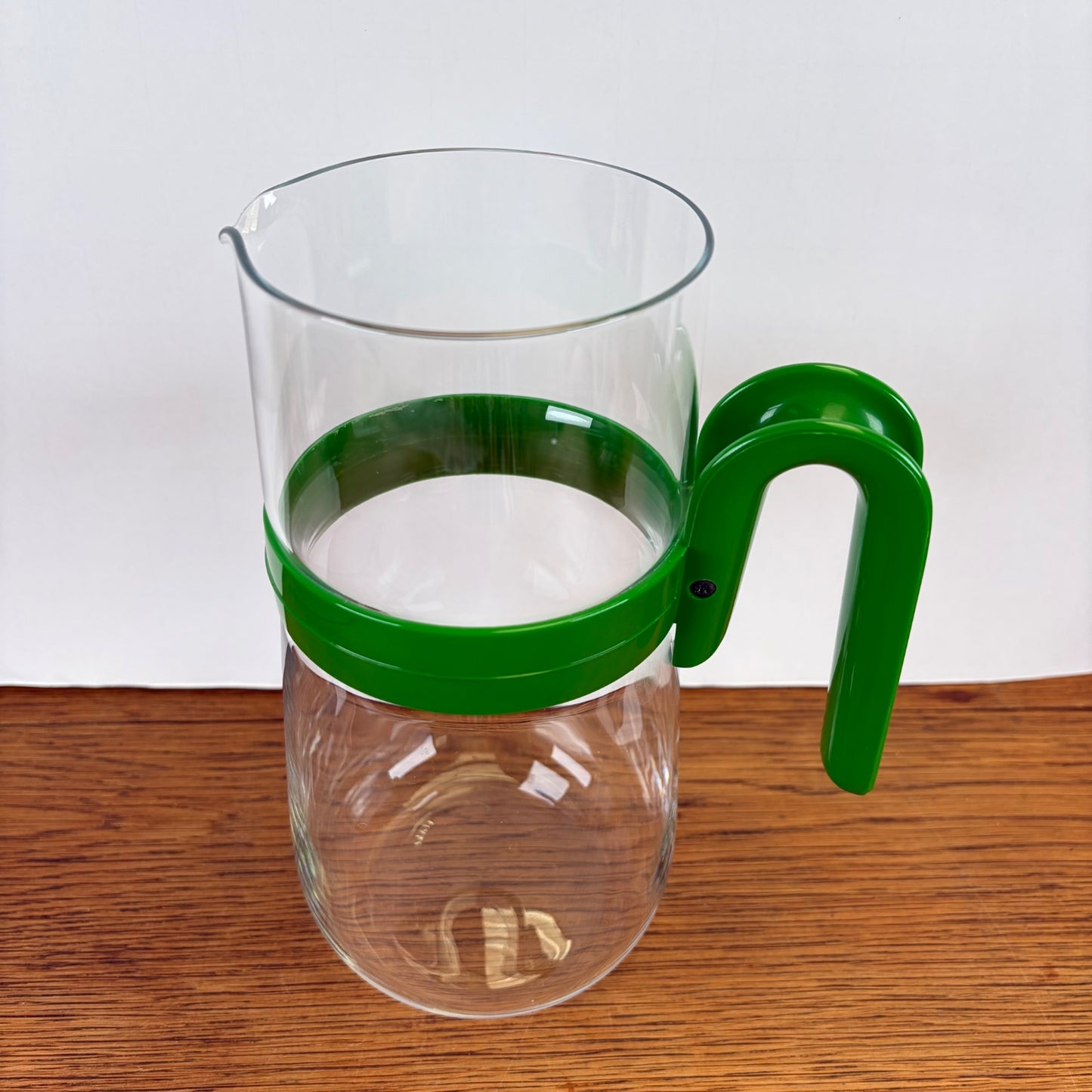 Vintage waterkan met groene kunststof houder
