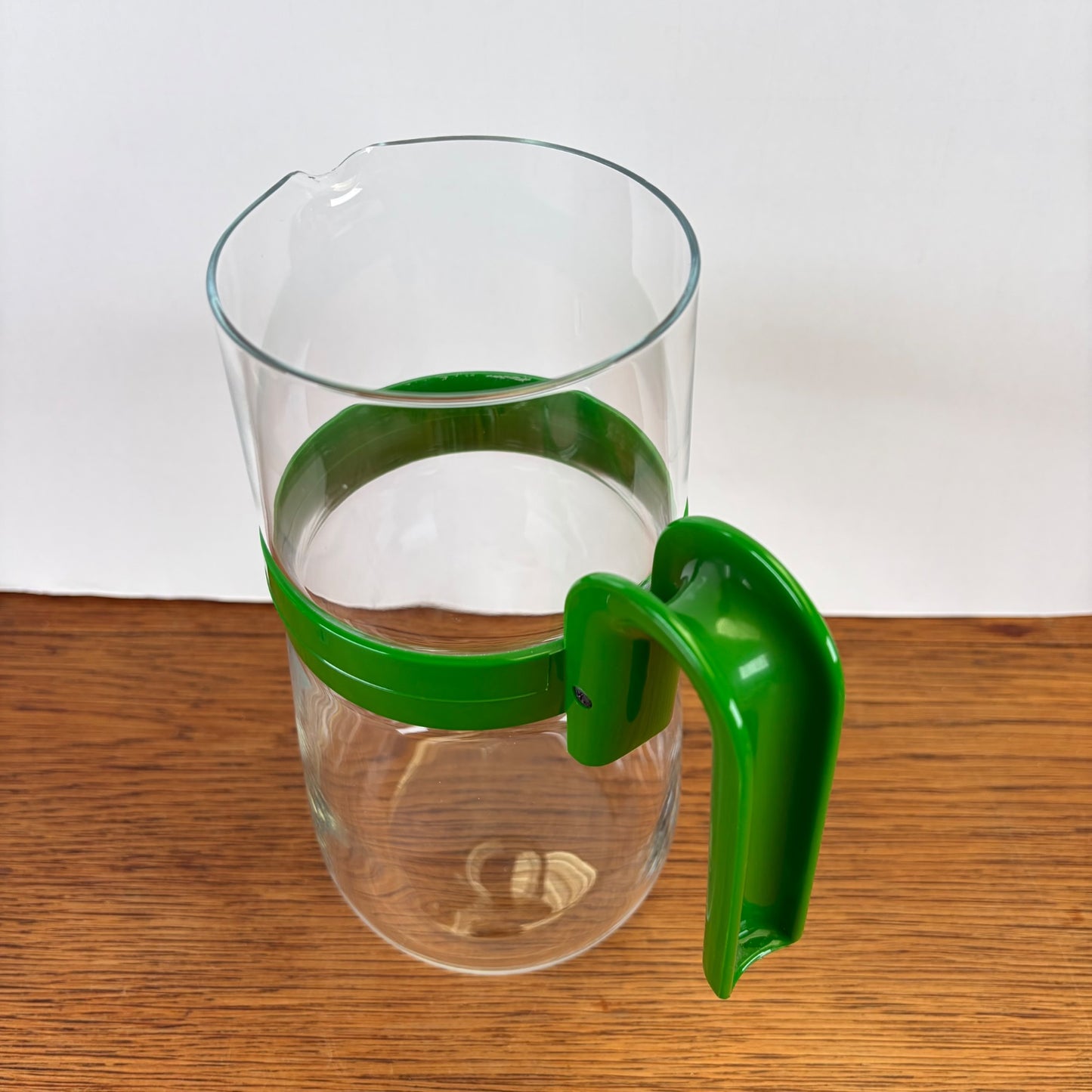 Vintage waterkan met groene kunststof houder